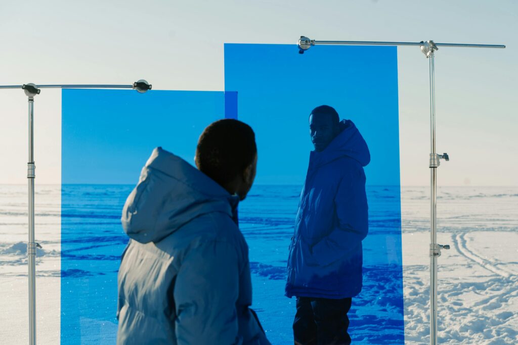 Men Wearing Blue Jackets in a Valley Covered with Snow