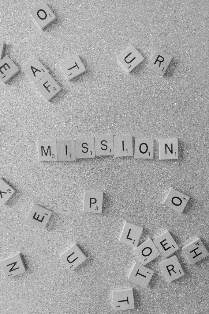 Scrabble tiles spelling 'MISSION' on a glittery surface, a symbolic and creative concept.