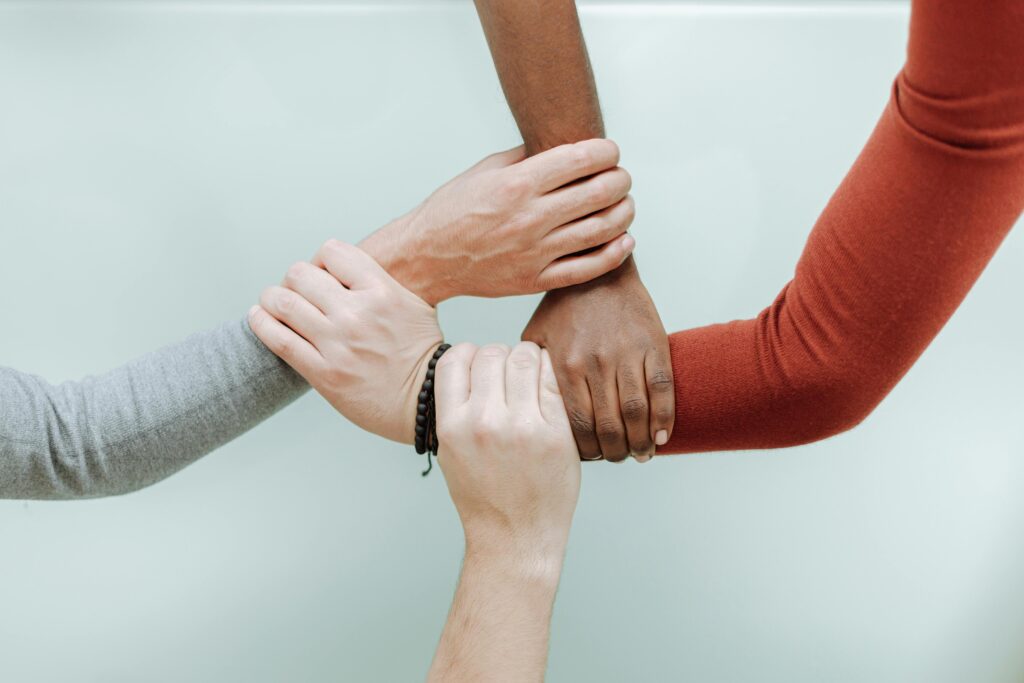 Close-up of diverse hands holding each other in a symbol of unity and togetherness.