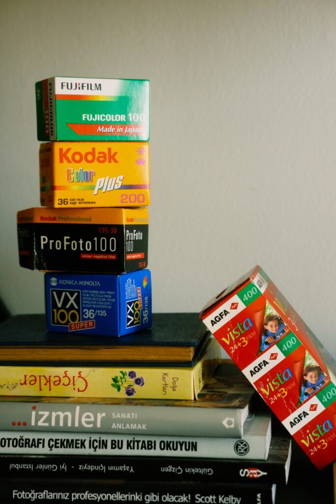 pexels-photo-17564017-17564017 Vertical stack of vintage film boxes and books with artistic composition.