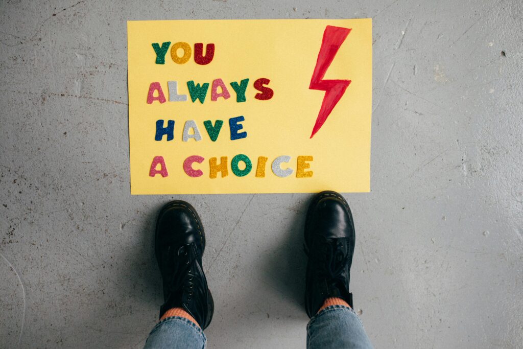 pexels-photo-5871631-5871631 A colorful motivational message on yellow paper viewed from above, showing feet in black shoes.
