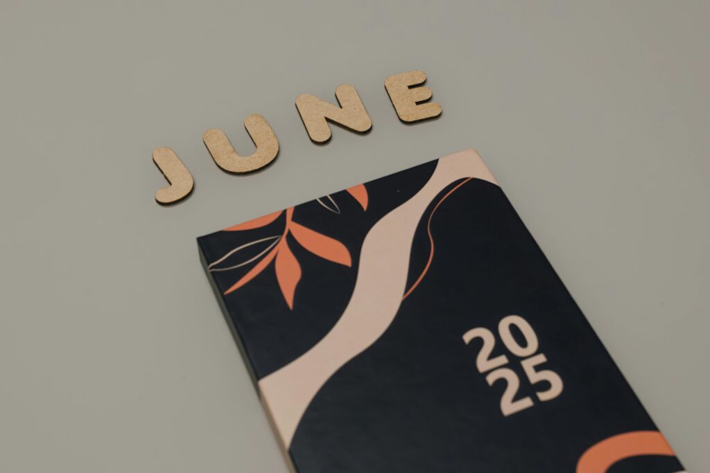 pexels-photo-29509409-29509409 A modern 2025 planner with wooden 'June' letters on a minimalist background.