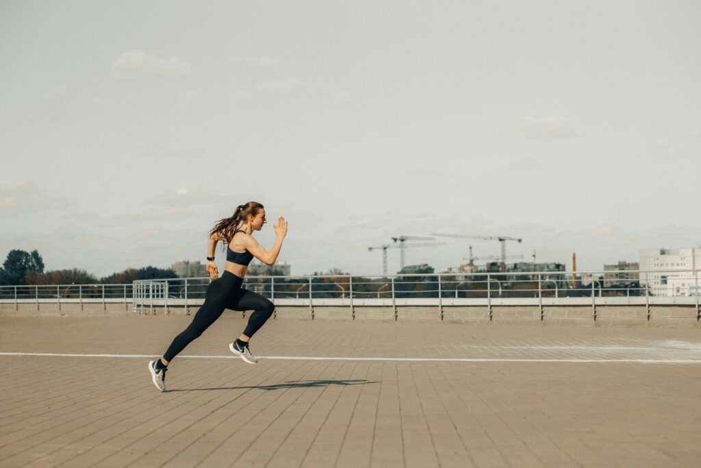 pexels-photo-4775192-4775192 Woman sprinting on a rooftop in athletic wear during the day.