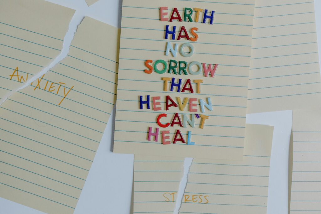 pexels-photo-8383669-8383669 Torn papers with an uplifting quote emphasizing healing and overcoming anxiety and stress.