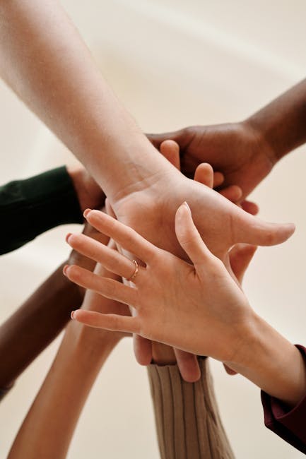pexels-photo-6146693-6146693 A close-up of diverse hands joined together symbolizing teamwork, cooperation, and unity indoors.