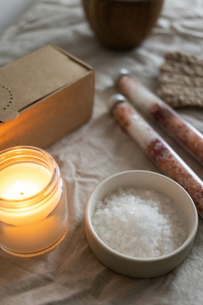 pexels-photo-6766263-6766263 Warm and calming aromatherapy setup featuring candle, salt, and natural elements.
