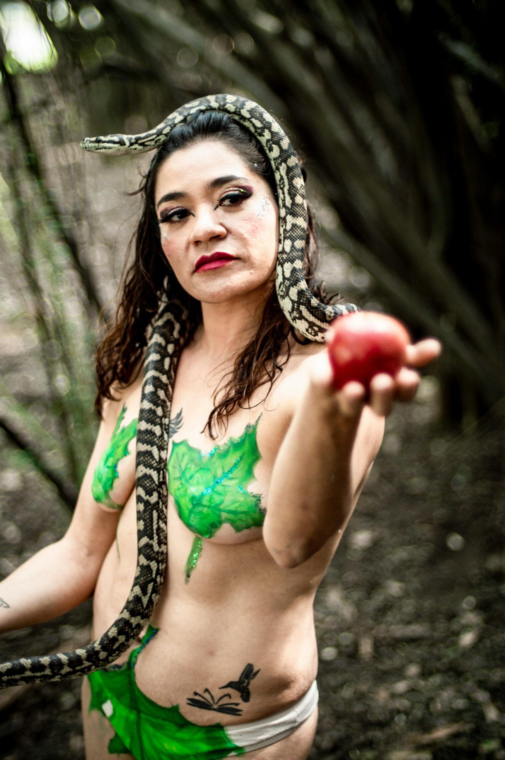 A symbolic portrayal of a woman outdoors with a snake and apple, in Chapultepec, Mexico.
