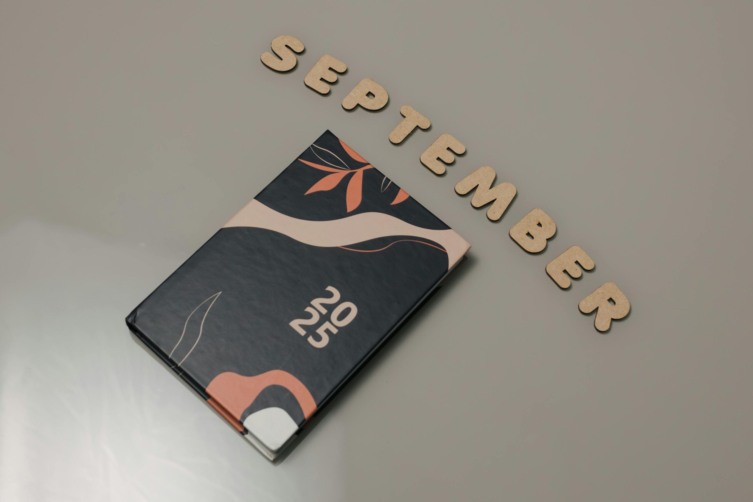 Stylish 2025 planner next to 'September' text, perfect for organization.