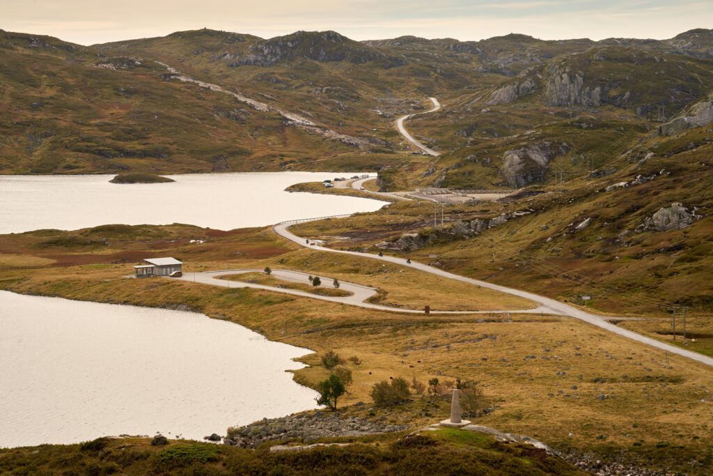 serene picnic spot near Rosskreppfjorden dam along Suleskarvegen road 450 in Norwegian highlands, Sirdal county, featuring motorcyclists cruising amidst scenic landscapes