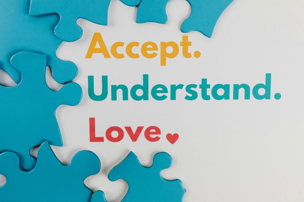 Colorful puzzle pieces with words 'Accept. Understand. Love.' symbolize autism awareness.