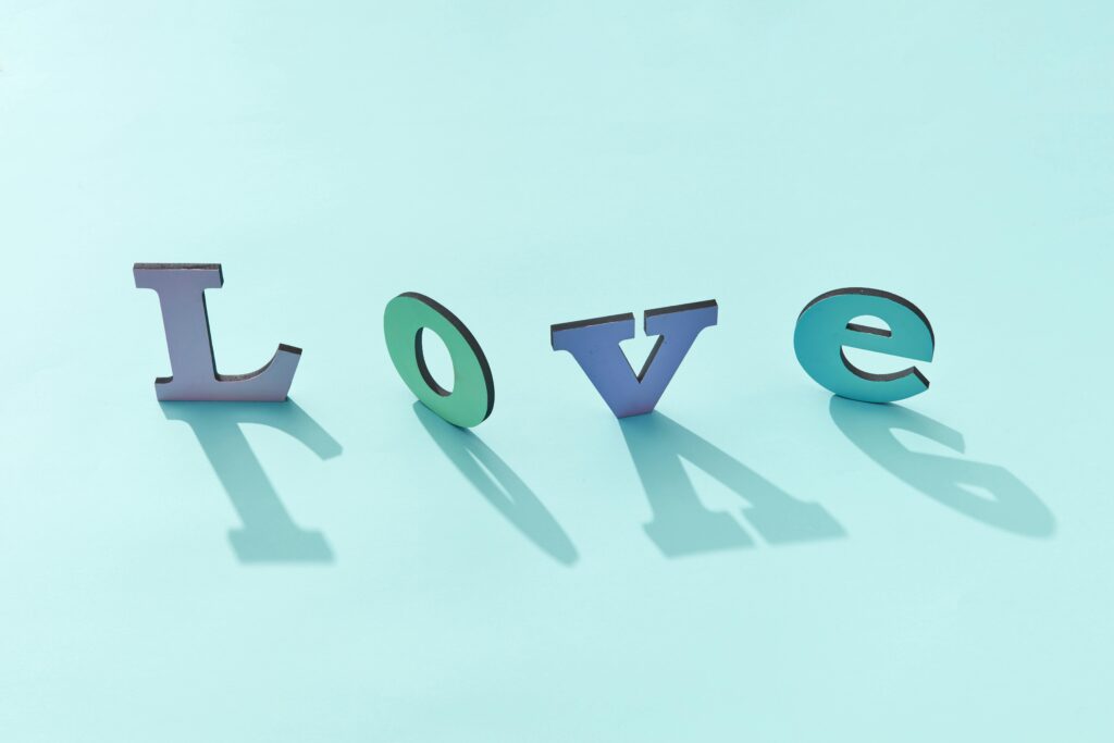 Colorful letters spelling 'Love' with shadow effects on a blue background.